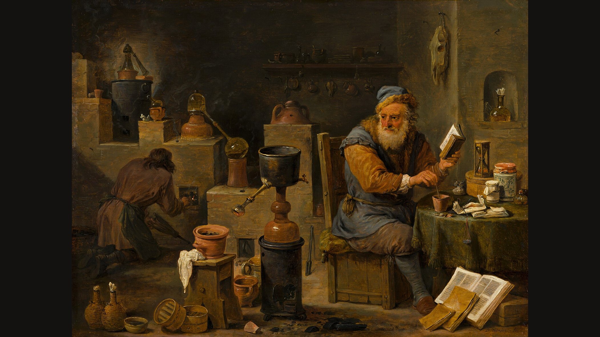 David Teniers's painting of an alchemist's workshop: an old man with a white beard sits reading a book beside a furnace with copper and glass vessels, while a helper tends the fire in the background