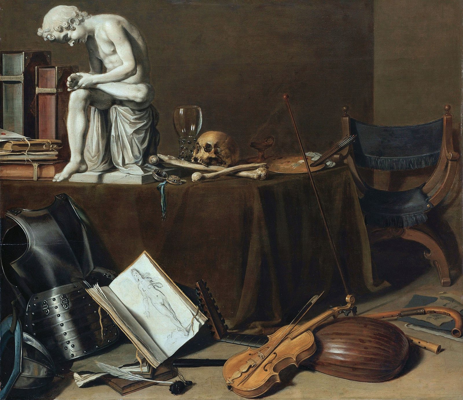 A painted vanitas still life: a white plaster statue of a boy pulling a thorn from his foot beside a skull and bones on a draped table, with books, a watch and an unlit lamp, and a suit of armor, a lute and a violin on the floor