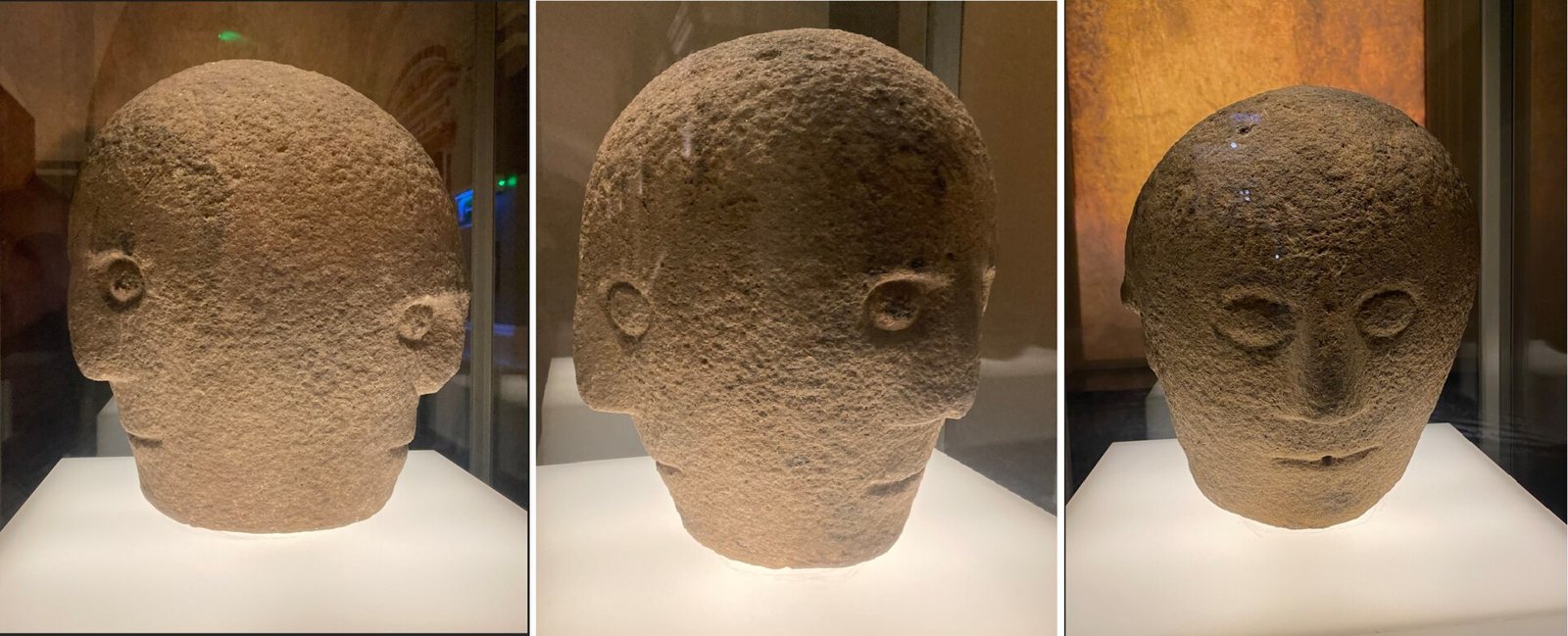 Three photographs of the Corleck Head side by side, showing its three rounded stone faces in turn, each with raised oval eyes and a straight nose
