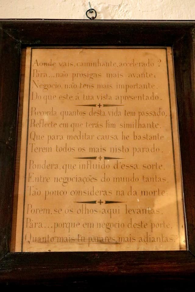 A framed panel with a Portuguese poem in four stanzas, beginning Aonde vais, caminhante, acelerado?