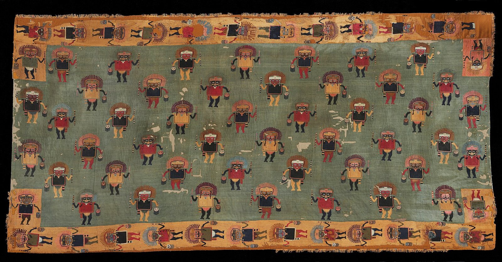 A Paracas ceremonial mantle on a black ground: rows of embroidered standing figures in feather headdresses, each holding small objects, on a green field framed by an orange border of more figures