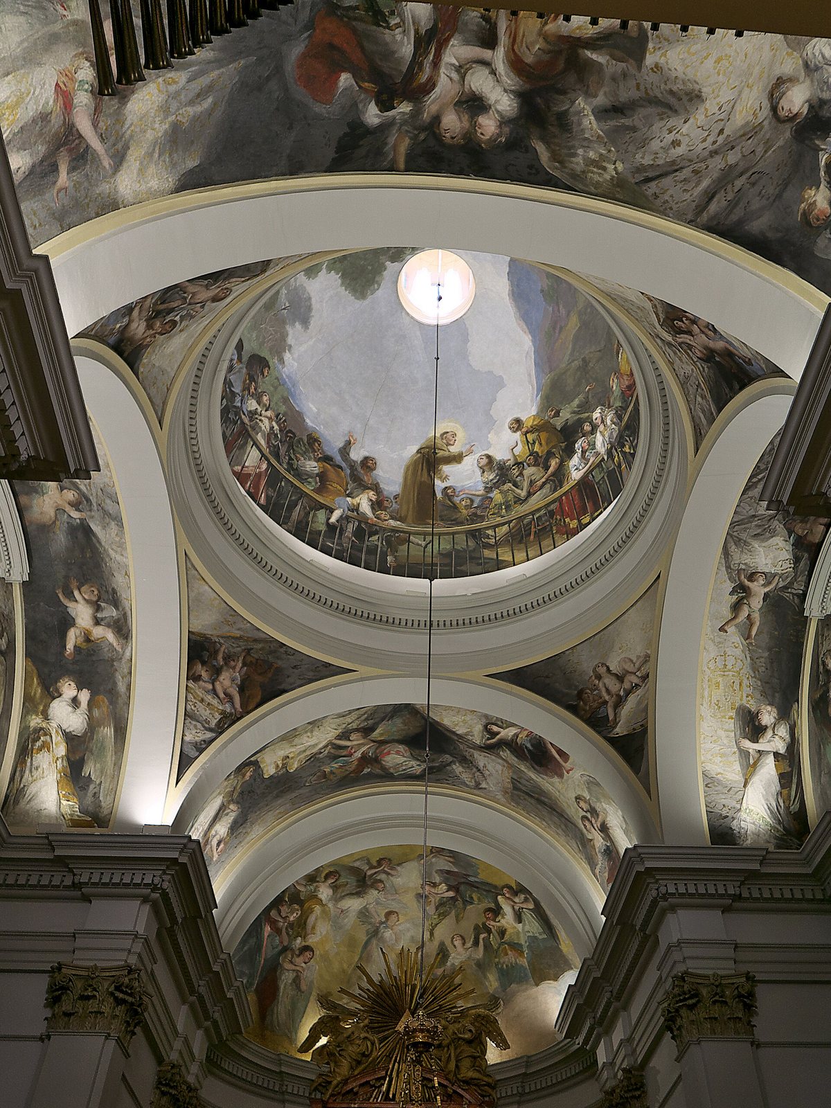 Looking up into the painted dome of San Antonio de la Florida, with Goya's frescoes of figures and clouds around the central cupola