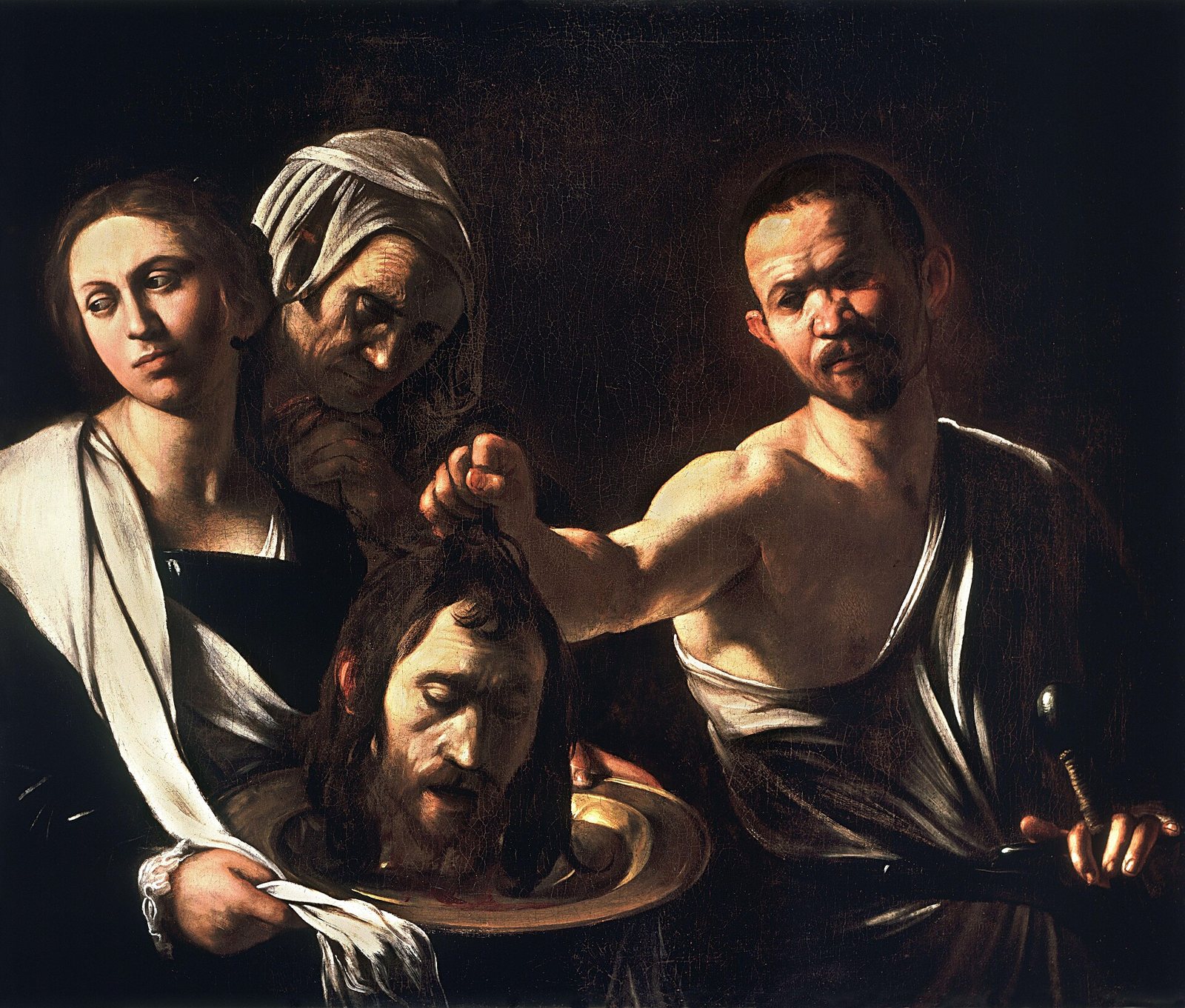 Caravaggio's painting in dark tones: an executioner holds the head of John the Baptist on a platter while Salome and an old woman look on