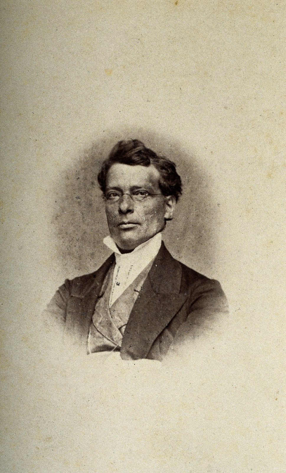 An oval-vignetted sepia portrait photograph of Joseph Hyrtl, a middle-aged man in glasses, a high white collar and a dark jacket