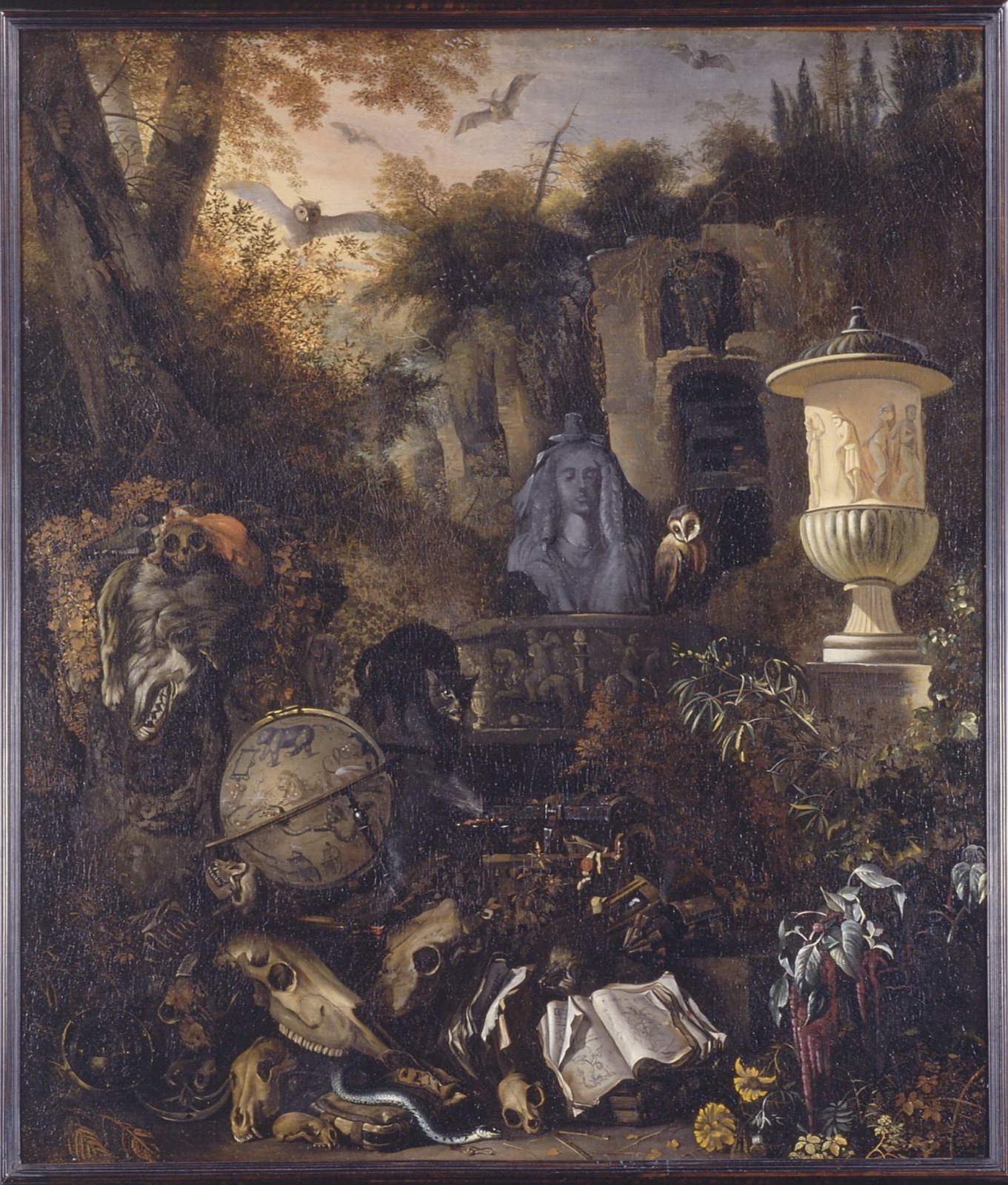 A dark wooded landscape with ruins, an urn and a stone bust, an owl perched by the urn, bats in the sky, and skulls, a globe, a book and a snake in the foreground