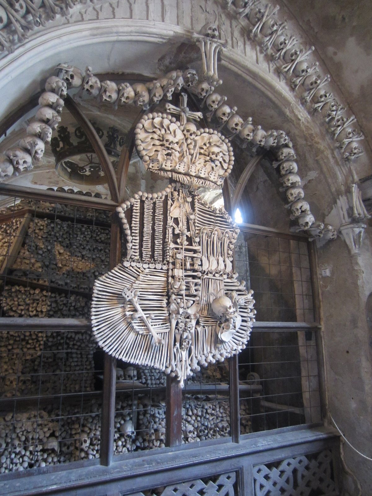 The Schwarzenberg coat of arms made of bones, with a crown at the top, set in an arched niche framed by bone garlands