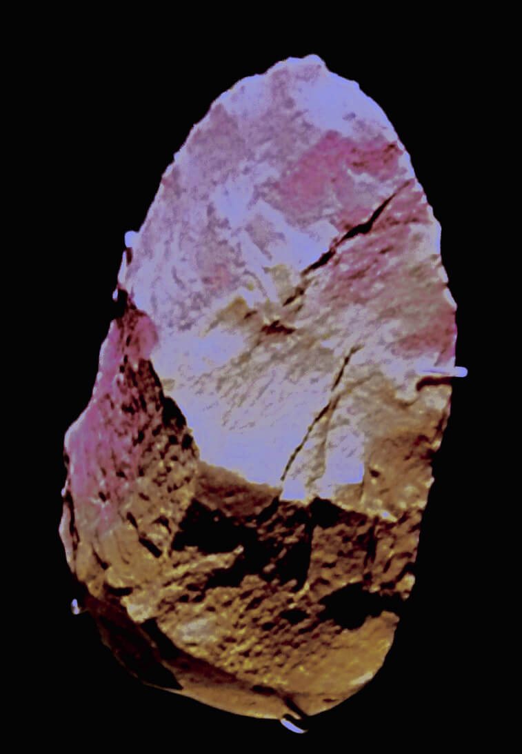 Pointed oval hand axe of red quartzite photographed against black, with pinkish and brown flaked faces