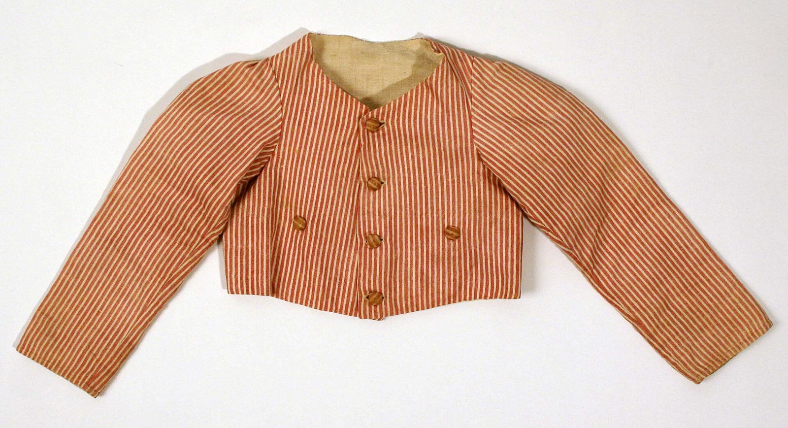 A short striped cotton jacket in narrow red-orange stripes with four brown buttons down the front, laid flat on a white background