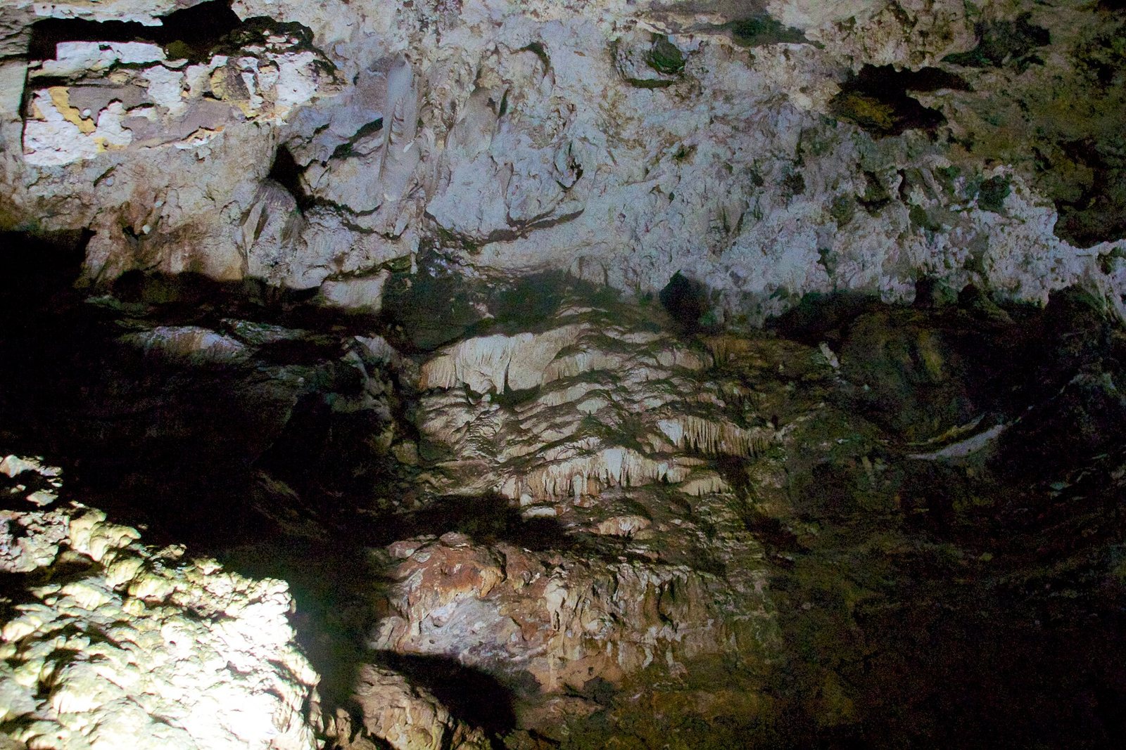 Inside a chamber of the Sterkfontein caves, with pale limestone walls, ridges of flowstone and deep shadows