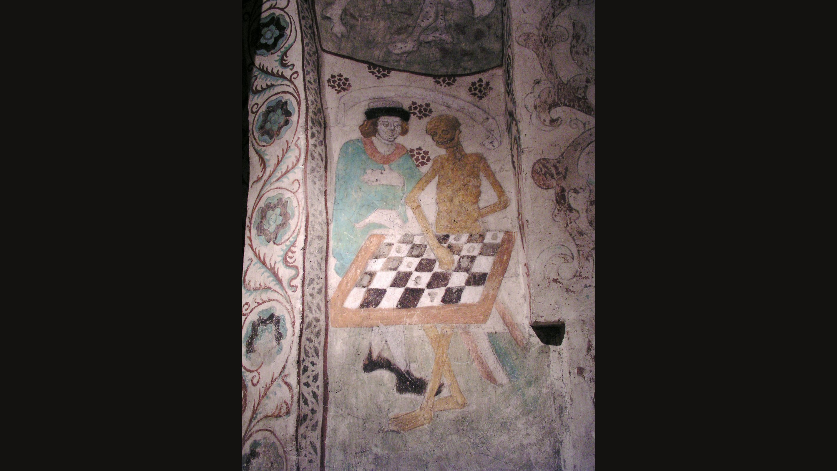 A medieval wall painting of a man in a blue-green cloak and dark cap playing chess against a yellow, skeletal figure of Death across a checkered board